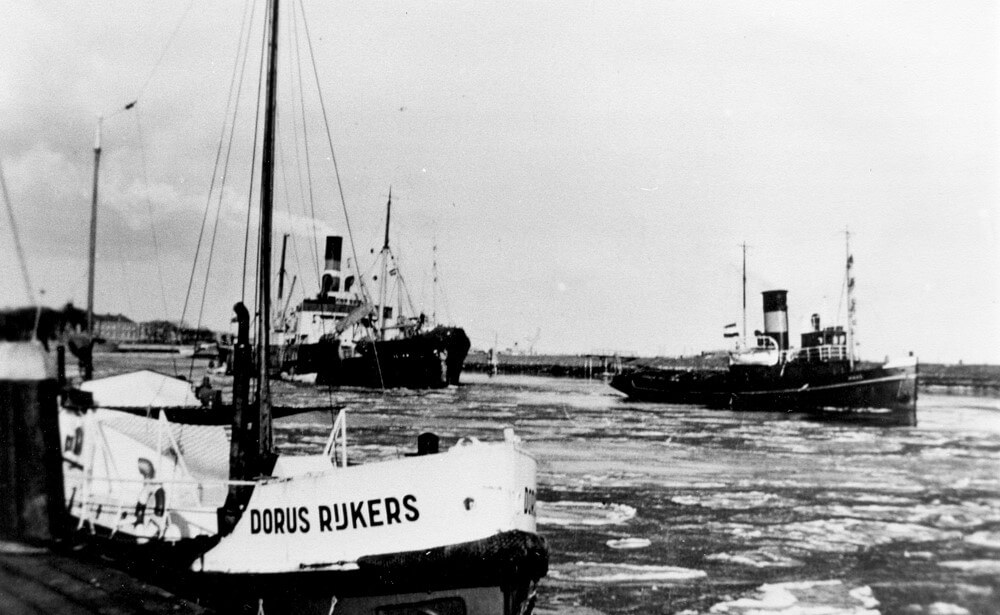 Aan de tros van de sleper Maas wordt de Lilian de haven van Den Helder binnengebracht