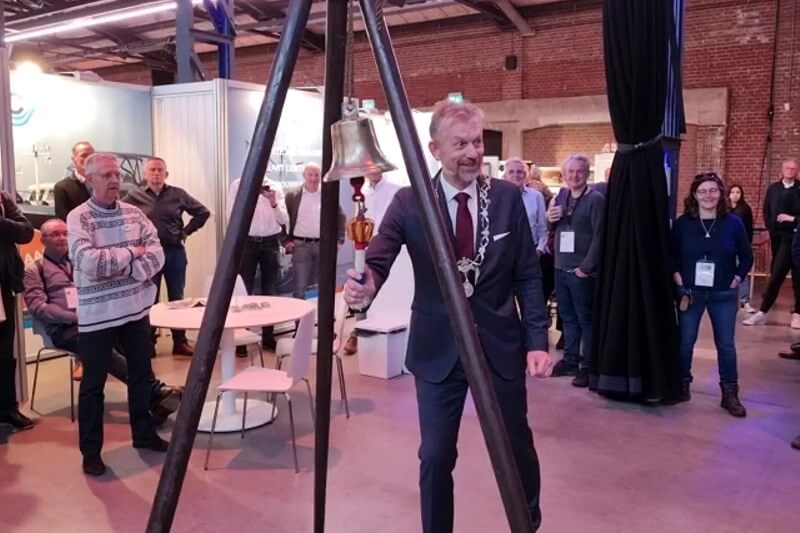 Burgemeester Jan de Boer opent met het luiden van een scheepsbel officieel de beurs.